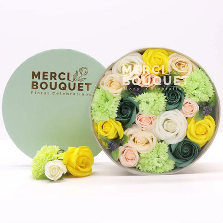 A round light green flower gift box with colorful soap flowers in yellow pink white and green for spring celebrations