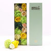 A flower gift box of yellow and green soap flowers including roses and carnations in a mint green merci bouquet box