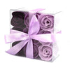 Soap flowers shaped like lavender and dark purple roses in a clear gift box with a lavender satin ribbon