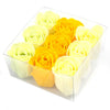 A clear plastic box of nine soap flowers shaped like spring roses in yellow and pale cream hues