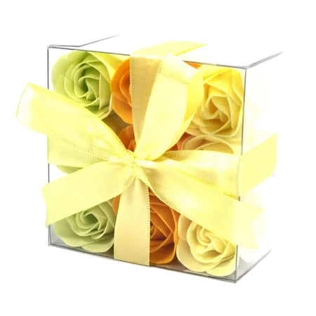 A clear gift box with pale yellow satin ribbon holding green and orange soap flowers spring roses set of 9