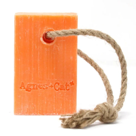 Orange rectangular soap on a rope with braided loop and agnes+cat brand name embossed on clementine scent bar