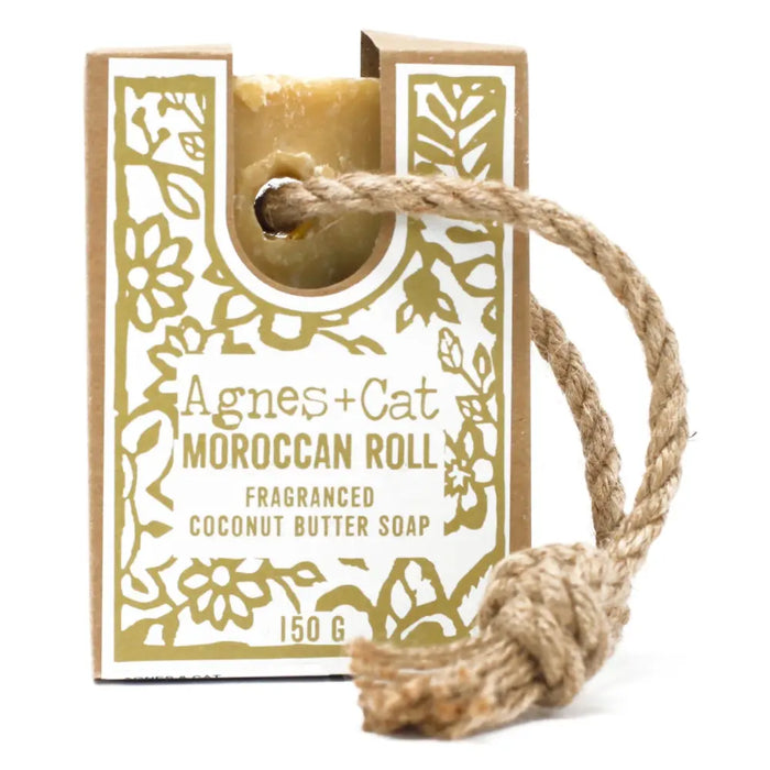 A golden rectangular bar of agnes and cat moroccan roll fragranced coconut butter soap with a braided rope loop
