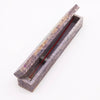 A rectangular soapstone incense box with a marbled purple and beige surface for holding soapstone incense