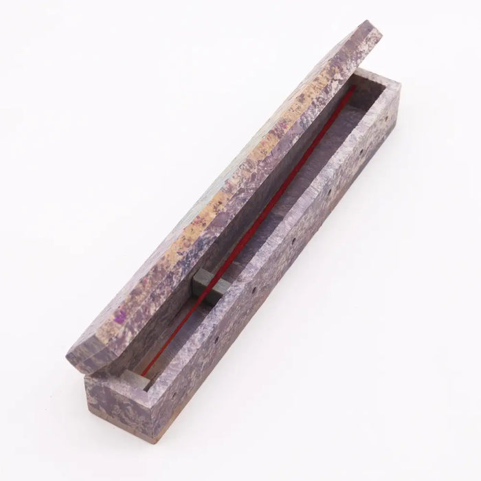 A rectangular soapstone incense box with a marbled purple and beige surface for holding soapstone incense