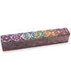 A rectangular soapstone incense box with a dark brown base and colorful chakra designs on top