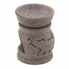 A speckled gray soapstone oil burner with carved elephant motifs on its sides