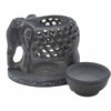 Dark gray soapstone oil burner shaped like a carved standing elephant with intricate lattice design and matching bowl