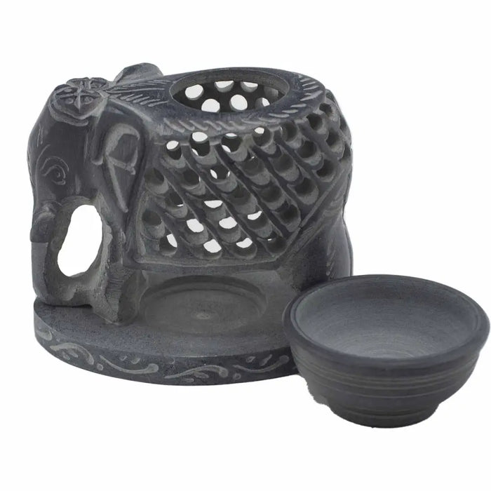 Dark gray soapstone oil burner shaped like a carved standing elephant with intricate lattice design and matching bowl