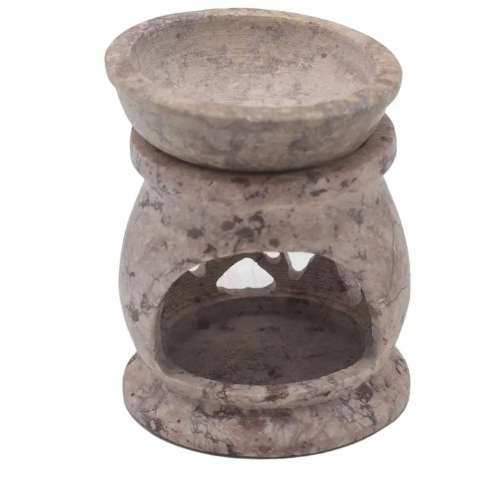 A rustic beige and gray speckled soapstone oil burner with a rounded bowl and open base for heating oil