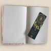 A navy blue dreamcatcher-themed bookmark with gold foil details and a small golden emblem for soft book dream journal