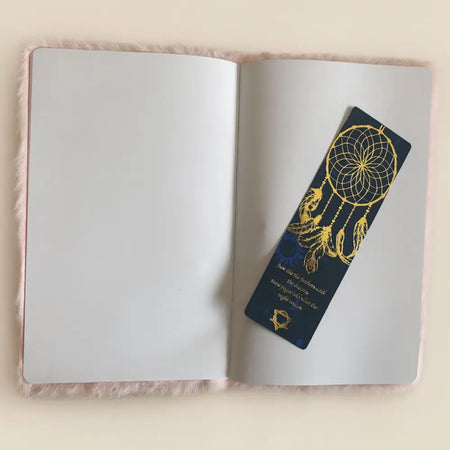 A navy blue dreamcatcher-themed bookmark with gold foil details and a small golden emblem for soft book dream journal