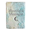A soft fluffy notebook with pastel blue and cream tie dye cover embroidered with moonlight messages and a crescent moon