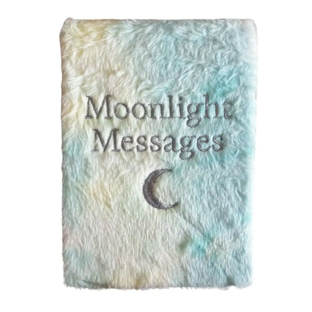 A soft fluffy notebook with pastel blue and cream tie dye cover embroidered with moonlight messages and a crescent moon