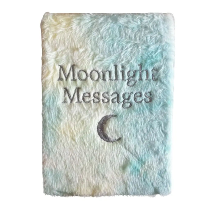 A soft fluffy notebook with pastel blue and cream tie dye cover embroidered with moonlight messages and a crescent moon