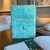 A soft light blue faux fur dream journal with moonlight messages embroidered in silver and a small crescent moon design