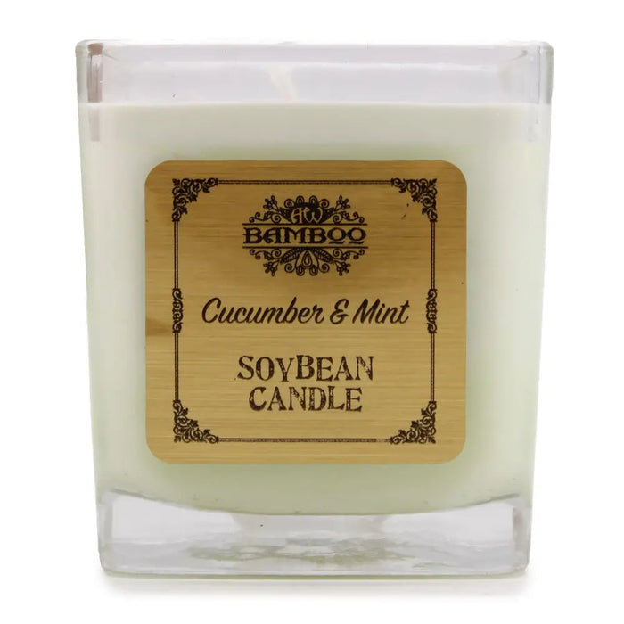 A square glass jar holds a creamy white 5cm soy wax candle with a bamboo cucumber and mint label and black borders