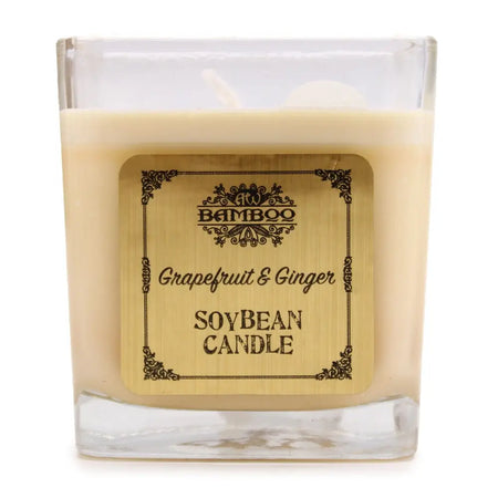 A square glass wax candle in creamy beige soy wax with a 5cm ornate bamboo label reading grapefruit and ginger