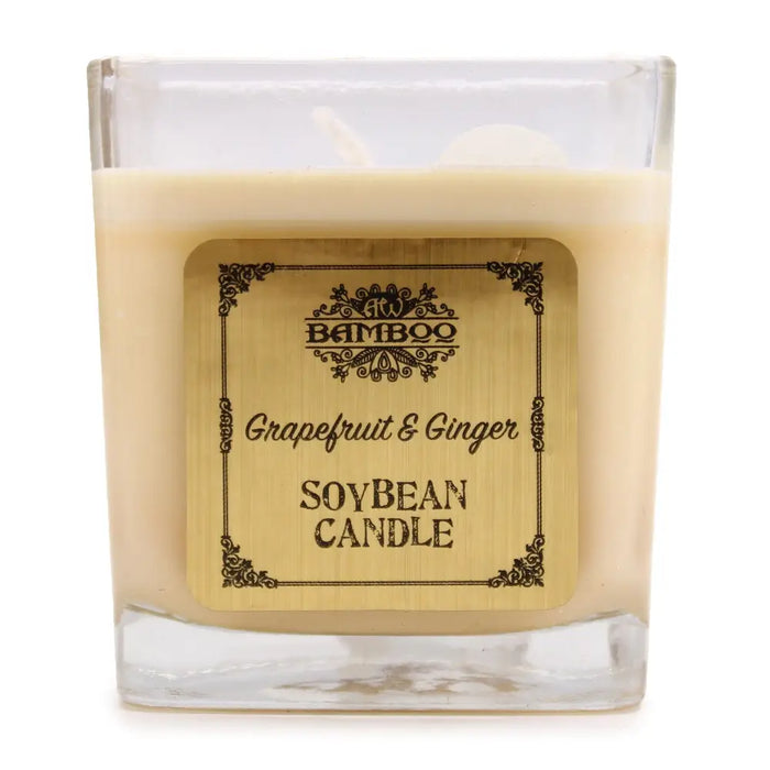 A square glass wax candle in creamy beige soy wax with a 5cm ornate bamboo label reading grapefruit and ginger