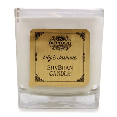 A white soy wax candle in a clear glass 5cm square jar with a gold ornate lily and jasmine label by bamboo
