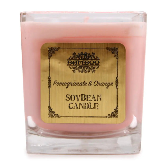 Pink pomegranate and orange soy wax candle in a clear 5cm square glass jar with an ornate gold label