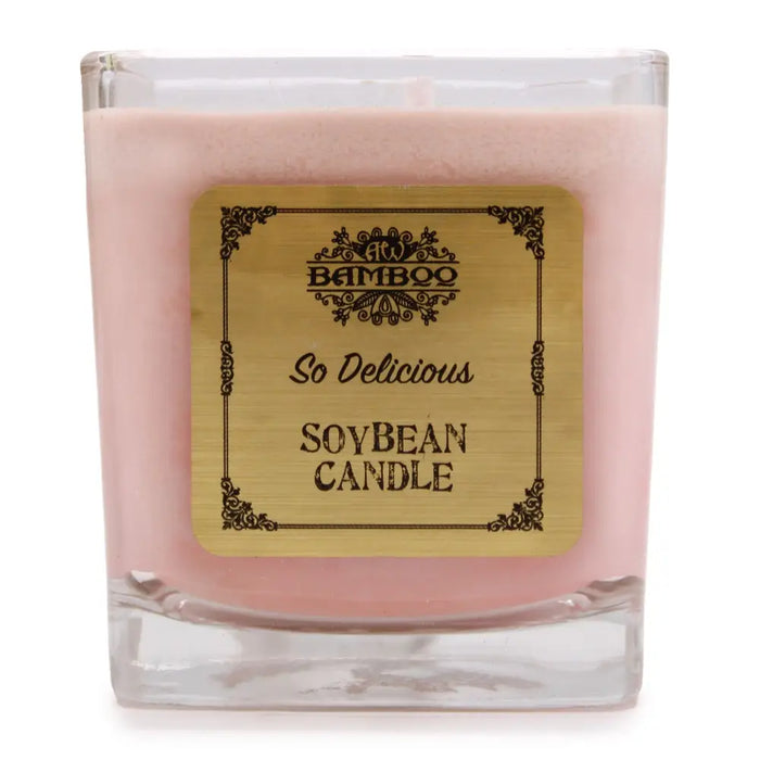 A pink 5cm soy wax jar candle in a clear glass container with a gold bamboo so delicious label