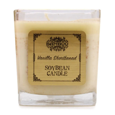 A creamy beige soy wax candle in a clear square glass jar with a bamboo style label vanilla shortbread 5cm tall