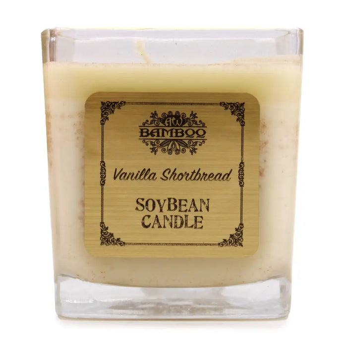A creamy beige soy wax candle in a clear square glass jar with a bamboo style label vanilla shortbread 5cm tall