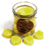 Bright yellow heart-shaped soy wax melts with cinnamon and orange scent in a clear glass jar with a rustic tag