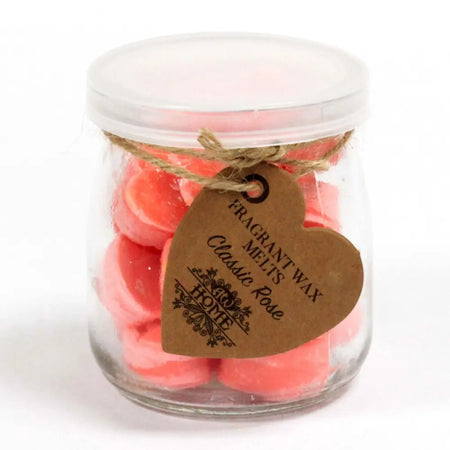 A clear glass jar of pink heart-shaped soy wax melts sealed with lid and tagged with twine for classic rose scent