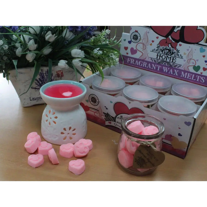 White ceramic wax melt burner with floral cutout and pink soy wax melts jar in dark sandalwood scent