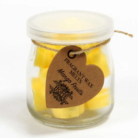 A clear glass jar of vibrant yellow mango-scented soy wax melts with a translucent lid and brown heart tag