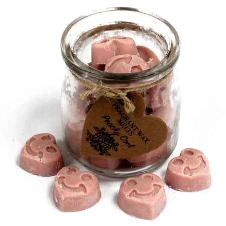 Pink heart-shaped soy wax melts in a clear glass jar with twine and a brown tag labeled peachy cool wax melts