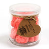 Pink tuberose-scented soy wax melts in a clear glass jar with heart-shaped brown tag labeled tuberose wax melts