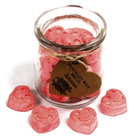 Pink heart shaped soy wax melts in a clear glass jar with a rustic brown tag scented with tuberose