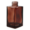 A sleek amber glass square reed diffuser bottle 100ml with a threaded neck for bamboo reed diffuser use
