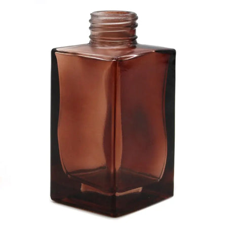 A sleek amber glass square reed diffuser bottle 100ml with a threaded neck for bamboo reed diffuser use