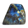 A polished madagascar labradorite stone showing blue gold and black iridescent hues on a smooth surface weighing 900-1100gm
