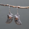 Sterling silver angel wing earrings with intricate filigree and 18ct yellow gold square accent at the center
