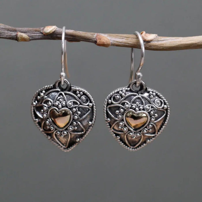 Sterling silver heart-shaped earrings with intricate filigree and a central 18ct yellow gold heart accent