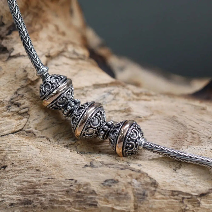 Sterling silver necklace with 18ct yellow gold charm beads and spacers on a braided metal chain