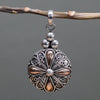 A sterling silver and 18ct yellow gold classic round drop pendant with a silver and rose gold filigree teardrop design