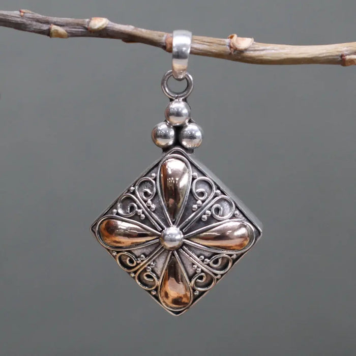 A sterling silver square drop pendant with 18ct yellow gold accents and intricate flower-inspired filigree design