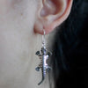 Sterling silver earrings shaped like lizards with detailed scales and textured limbs in a silver tone