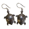 Sterling silver earrings shaped like turtles with detailed shell patterns and small circular silver embellishments on edges