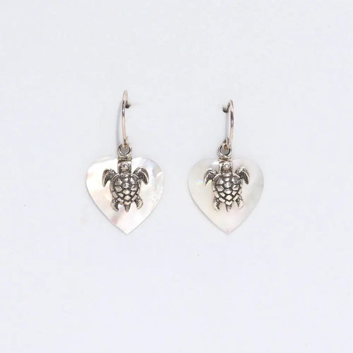 Sterling silver sea turtle charm earrings with heart shaped mother of pearl pendants on a white background