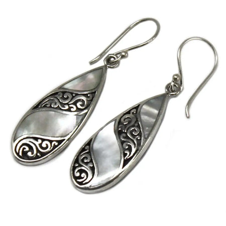 Sterling silver teardrop earrings with swirling filigree patterns and a central mother of pearl inlay
