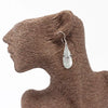 Sterling silver teardrop earrings with a translucent mother of pearl stone and three small heart details