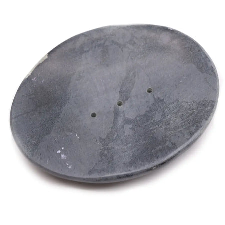 Dark gray classic oval soap dish made of soapstone with a textured surface and three small drainage holes
