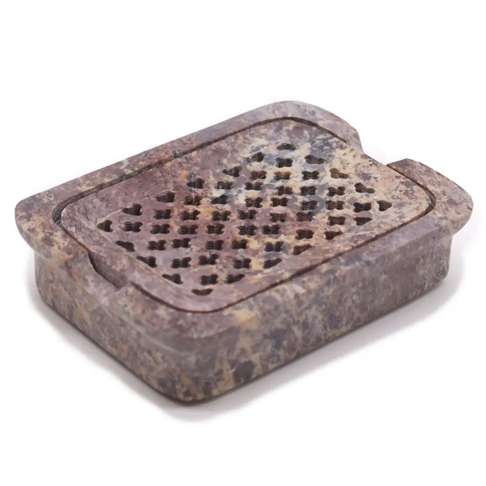 Rectangular stone soap dish with heart-shaped cutouts in mottled brown and beige soapstone with drainage feature